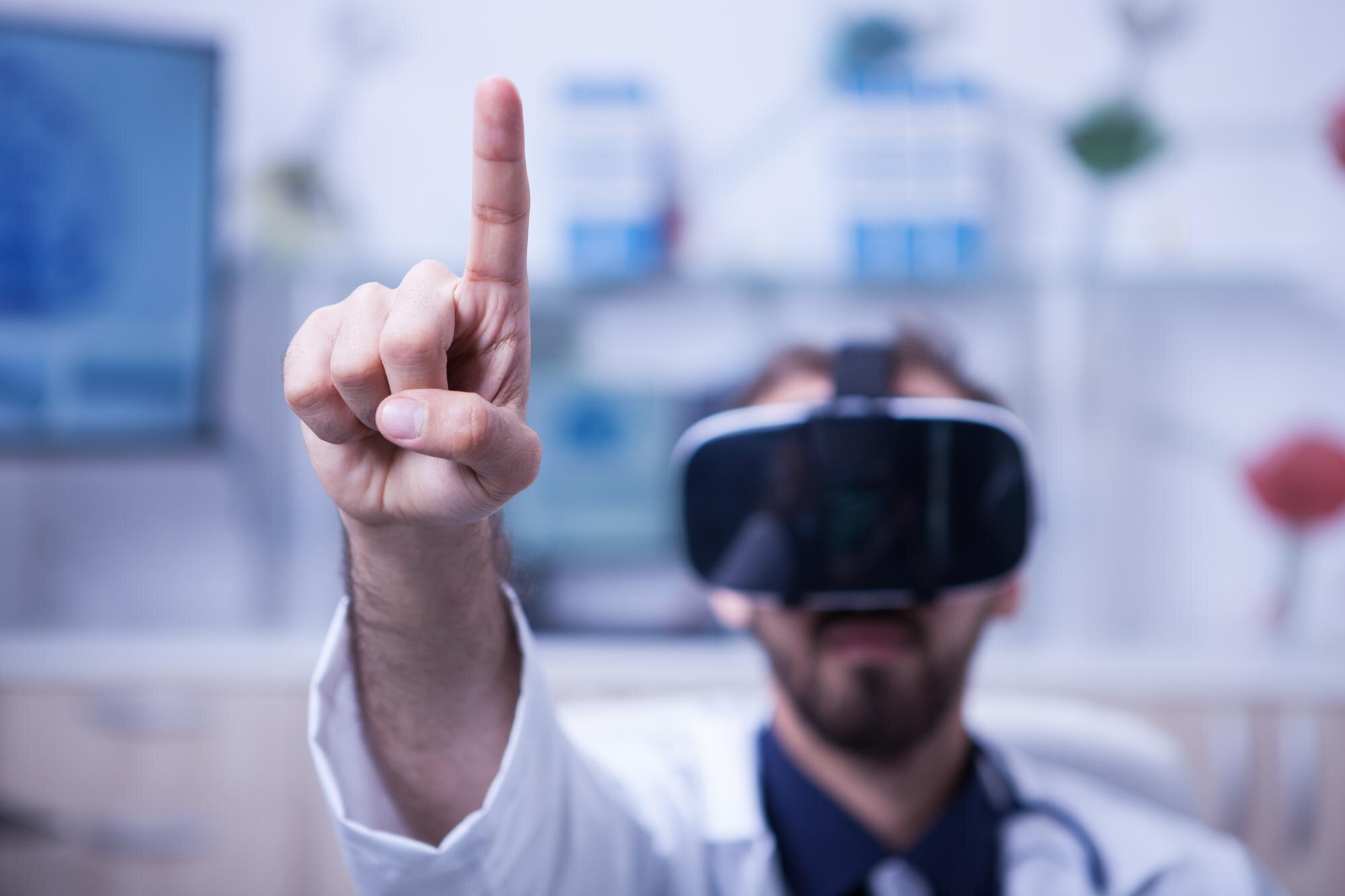 close-up-doctor-pointing-air-with-his-finger-wearing-virtual-reality-headset-doctor-his-medicine-uniform_482257-34630